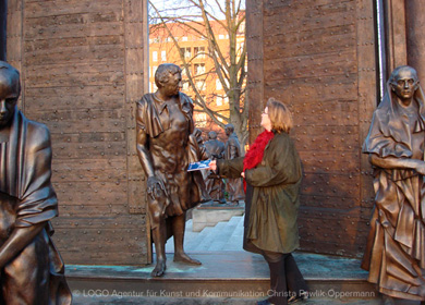 Platz der Göttinger Sieben - eine Frau überreicht einer Statue den Göttinger Terminkalender
